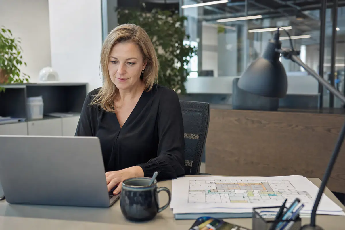 Facilitair manager plant de keuringen van het pand op haar laptop